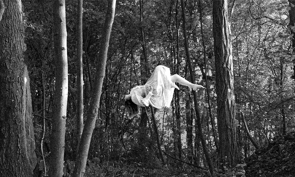 photographie d'une personne en levitation dans une fôret